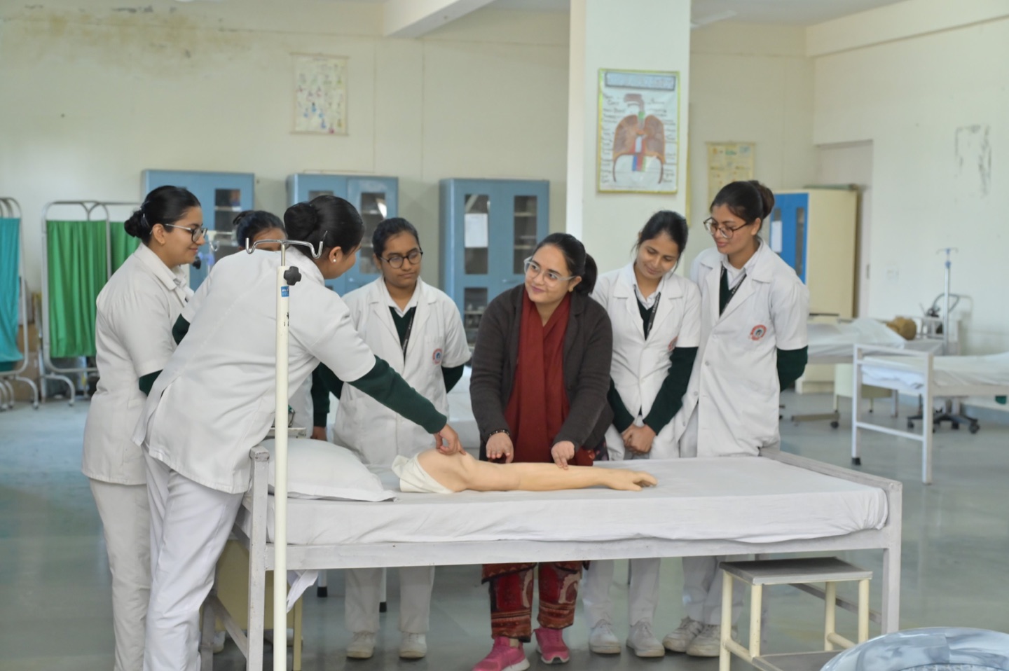 Nursing students receiving a supervised bedside-care demonstration in the shared campus skills lab